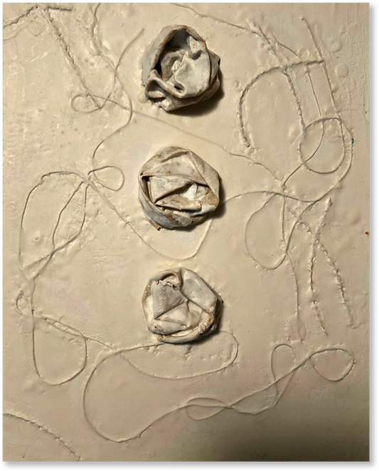 Three clay flower shapes on a textured beige surface with abstract lines.